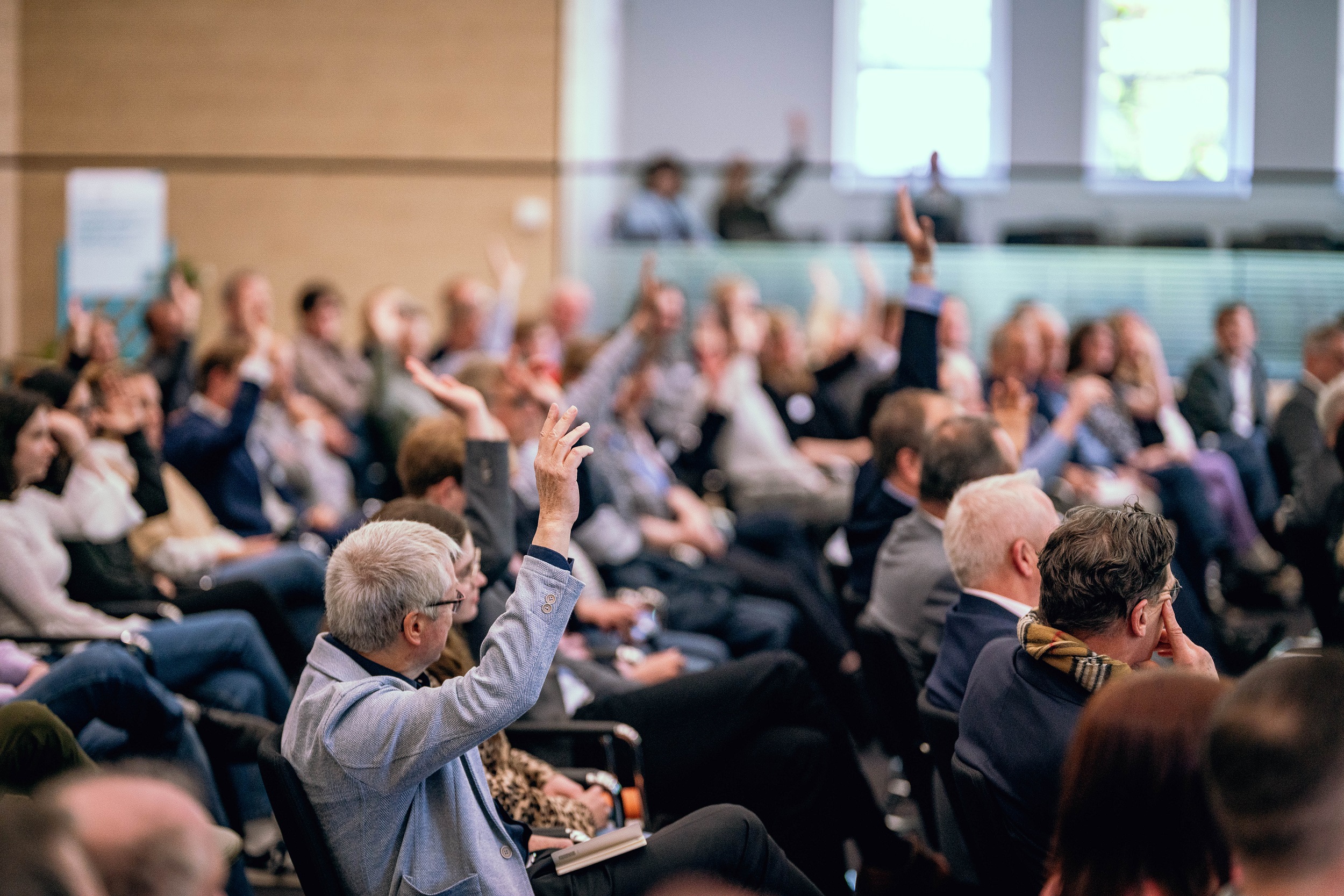 Voller Plenarsaal beim Regionalverband Ruhr. Einige Personen heben die Hand. 