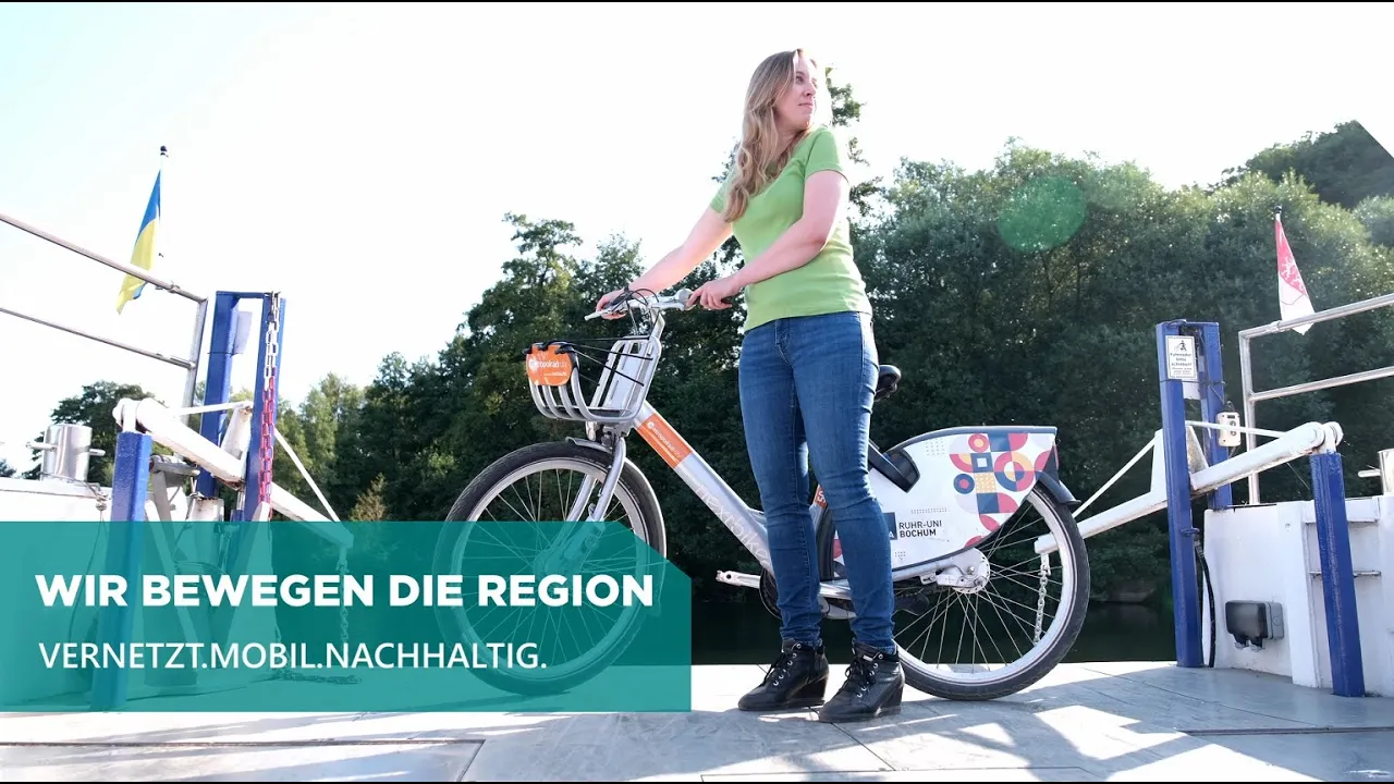 Frau mit Fahrrad auf der Ruhr-Fähre. Titel: Wir bewegen die Region, Vernetzt.Mobil.Nachhaltig