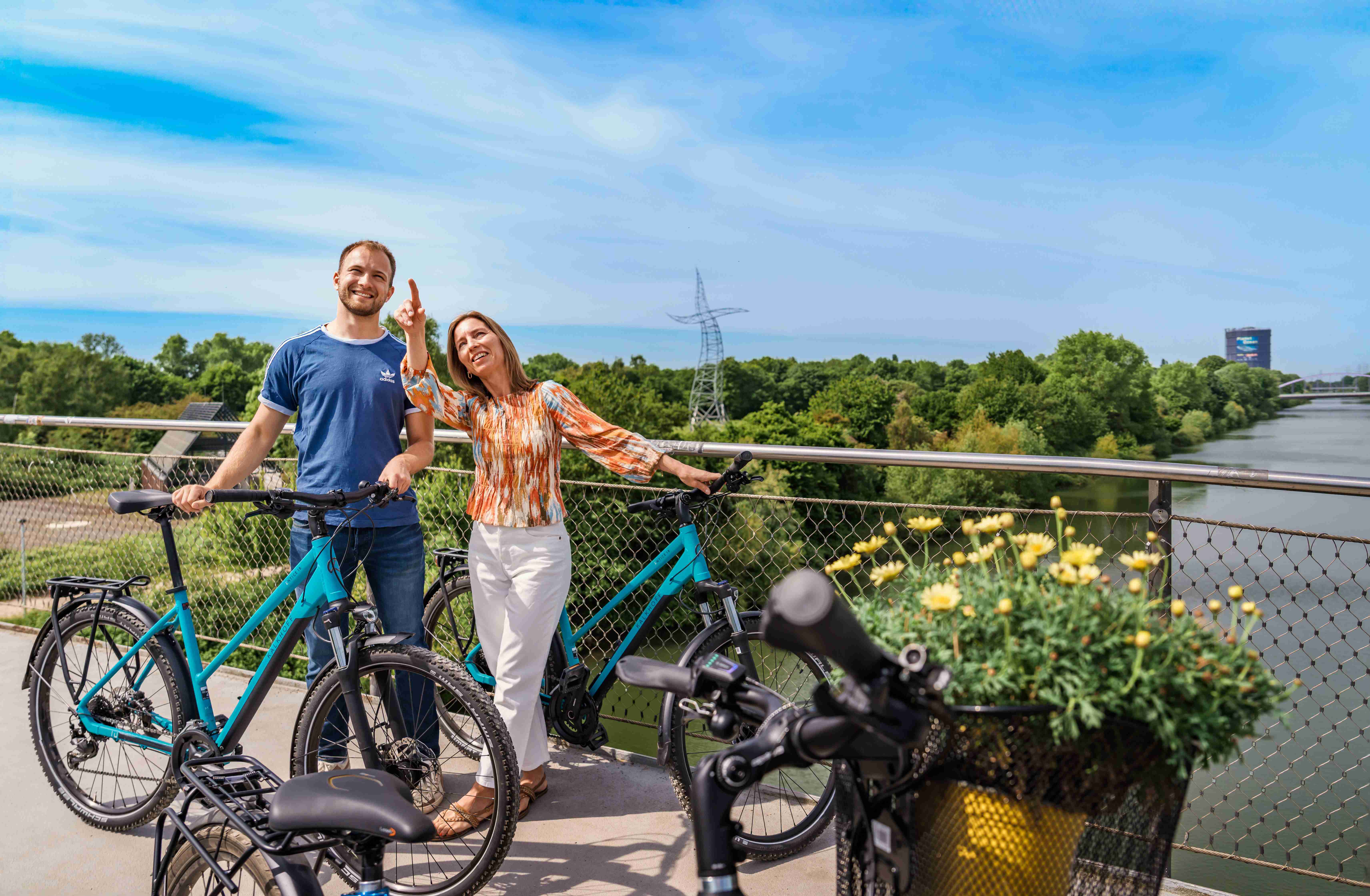 Zwei Personen stehen mit ihren Fahrrädern auf einer Brücke am Haus Ripshorst
